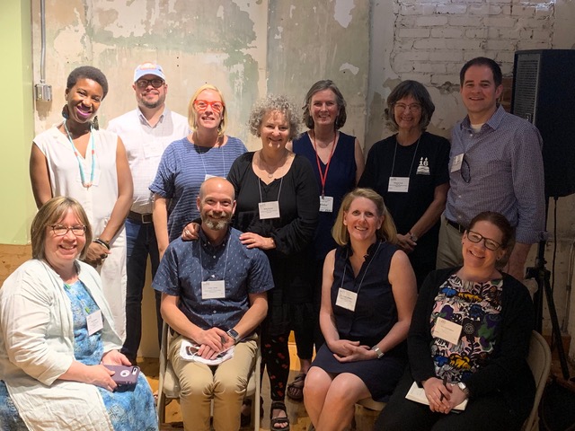 A picture of a group of 3 men and 8 women at what appears to be a conference.