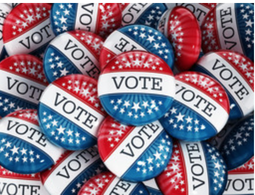 A picture of a pile of voting buttons in red, white, and blue,.