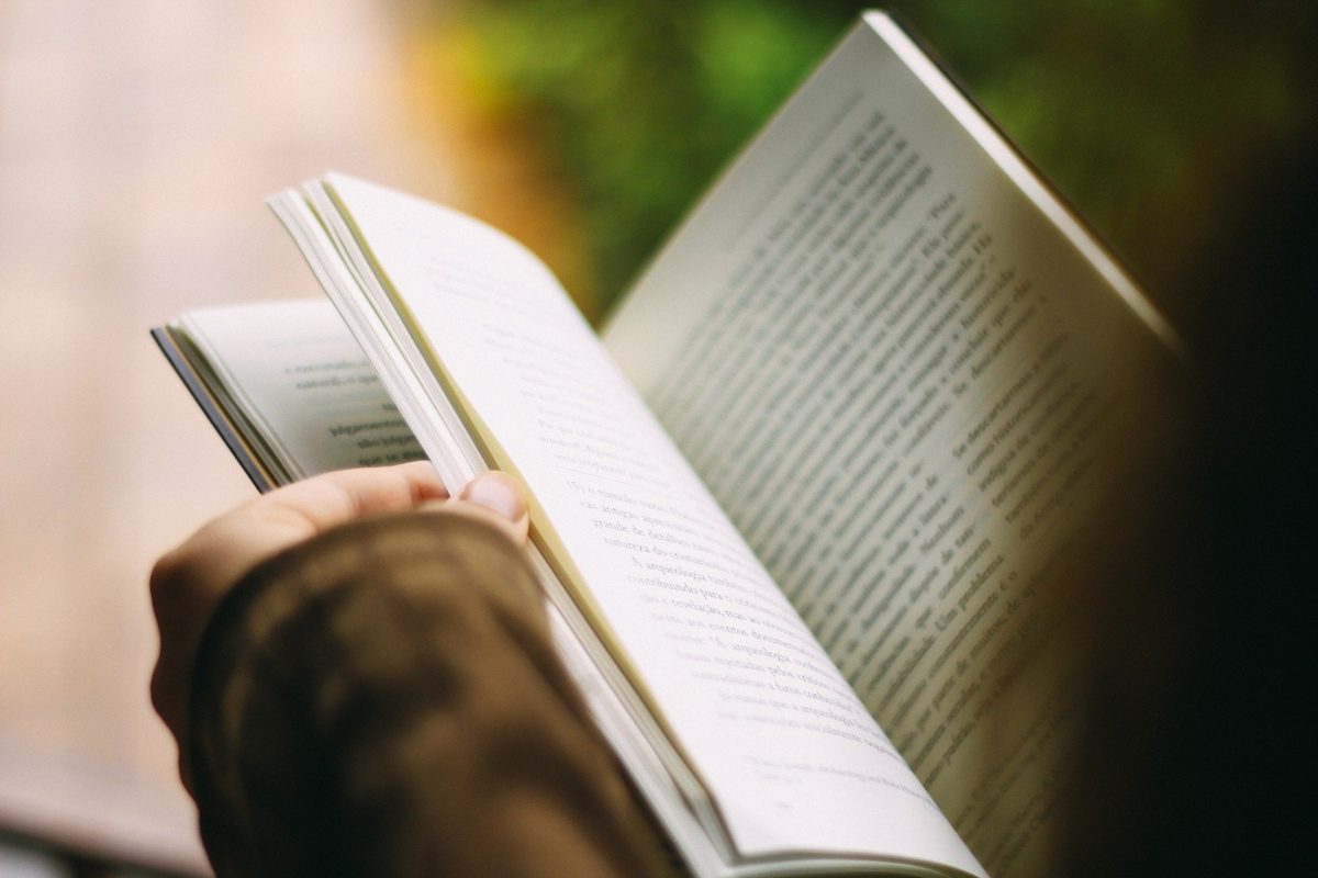 A blurry picture of a woman reading a book.