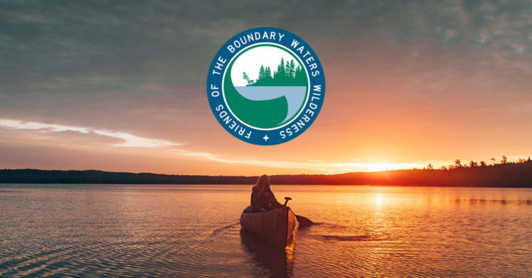 Person canoeing on lake at sunset with the Friends of the Boundary Waters Wilderness Logo above.