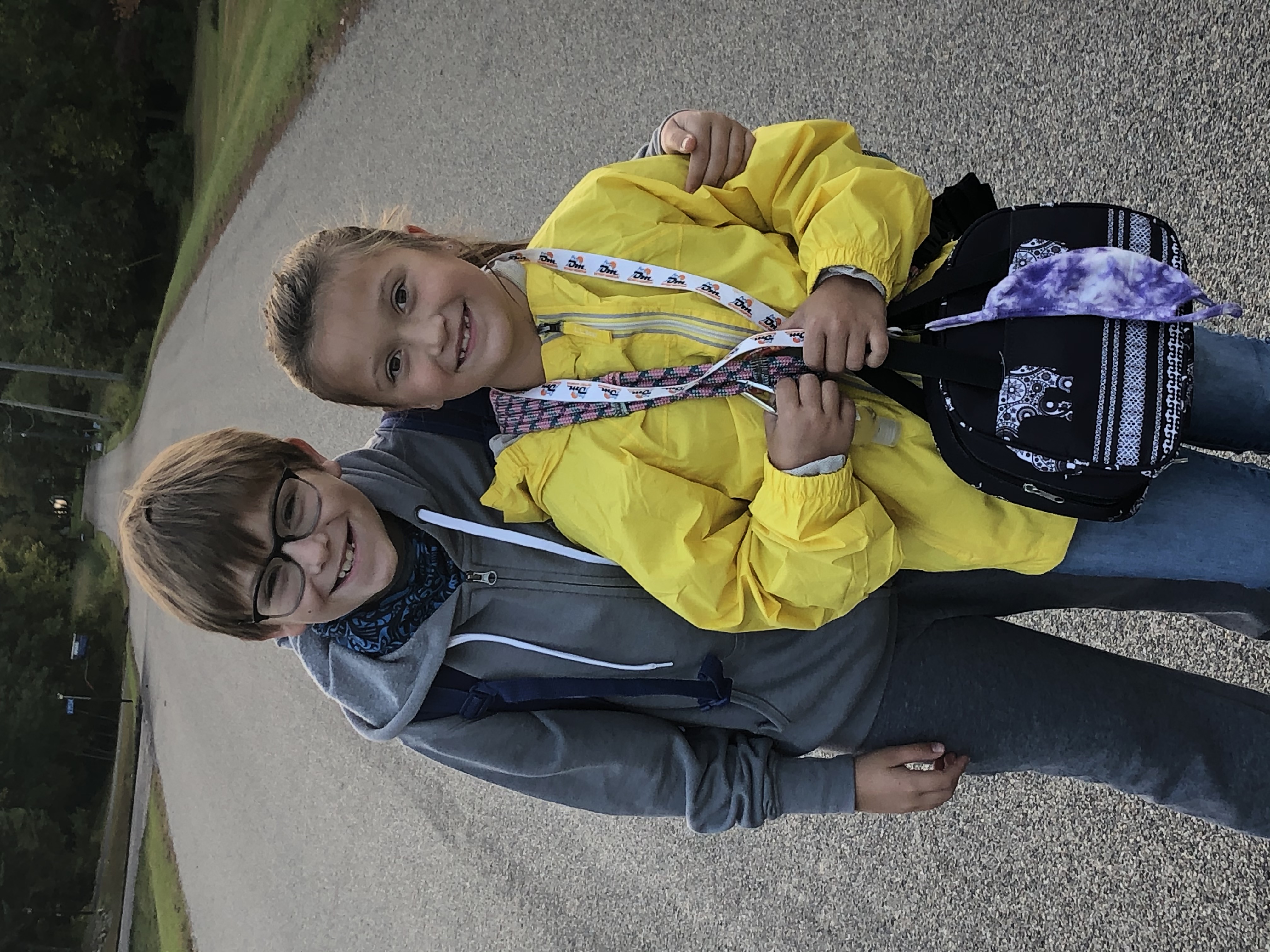 A picture of two child siblings smiling with their arms around each other.