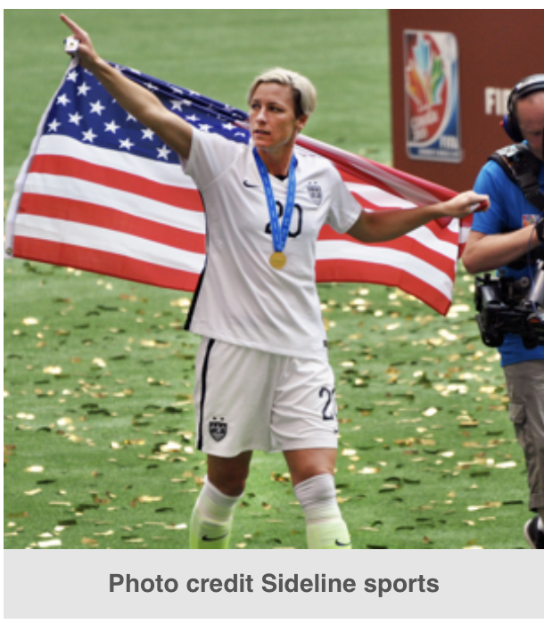 A picture of Abby Wambach in her soccer uniform holding the American flag.